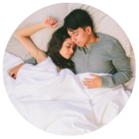 a couple cuddling underneath the silk cloud comforter